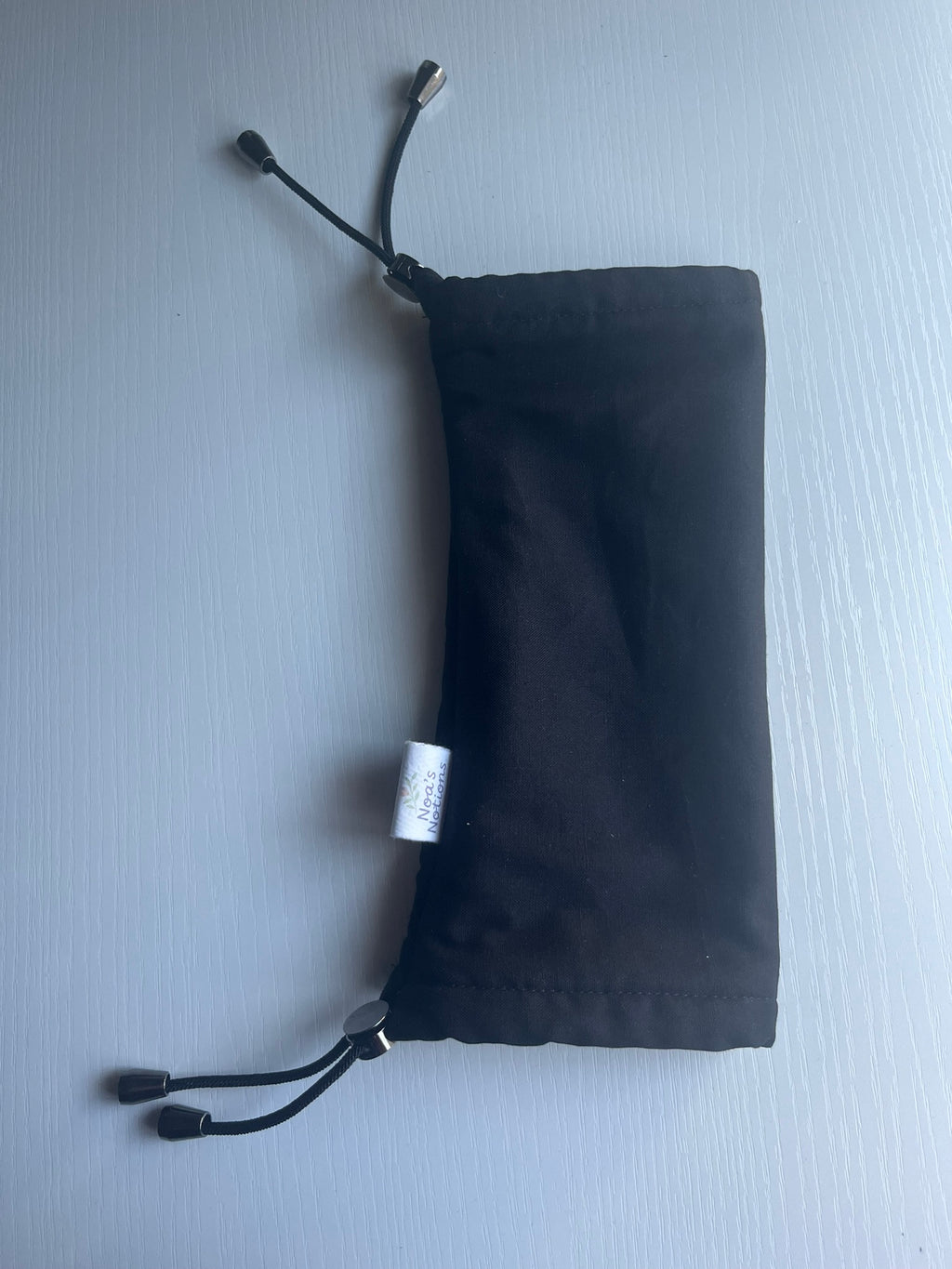 Black drawstring pouch on a light gray background