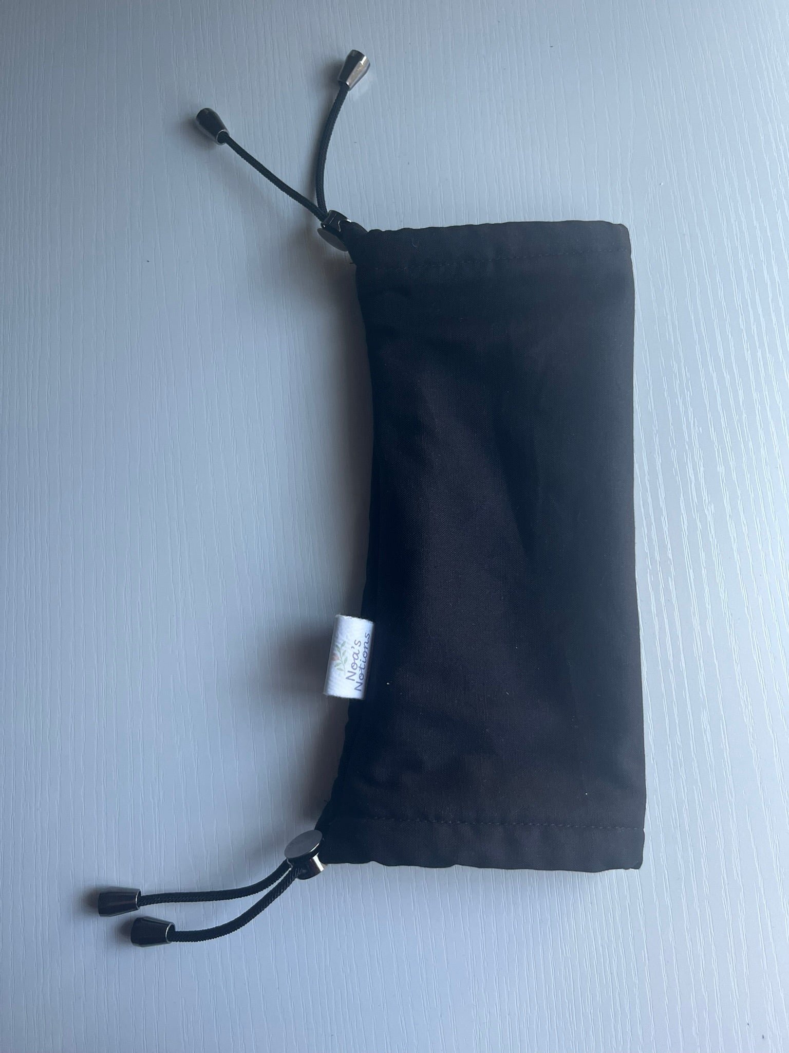Black drawstring pouch on a light gray background