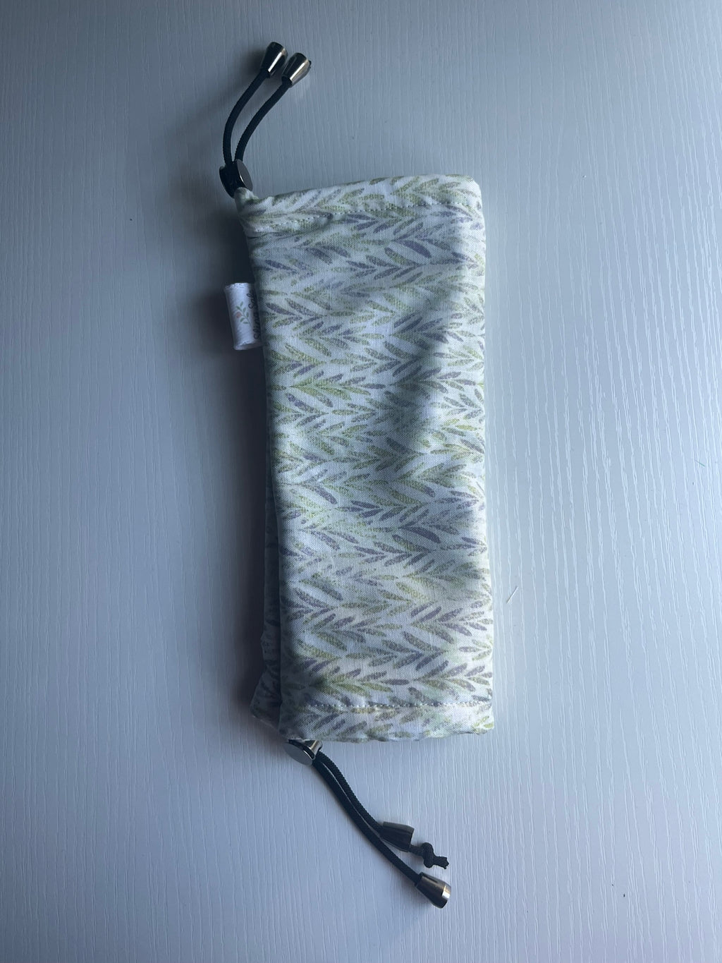 Fern-patterned drawstring pouch on a light gray background