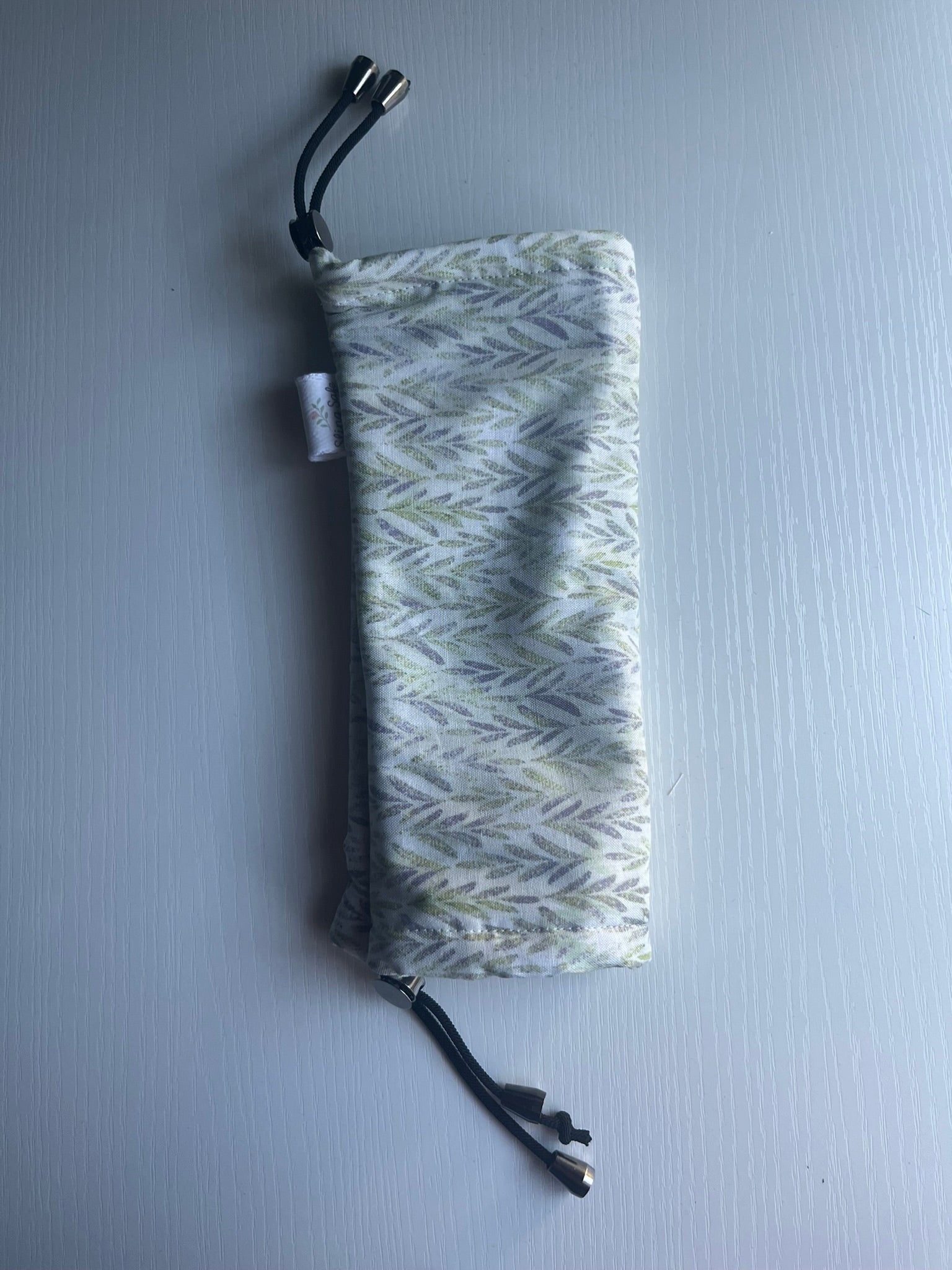 Fern-patterned drawstring pouch on a light gray background
