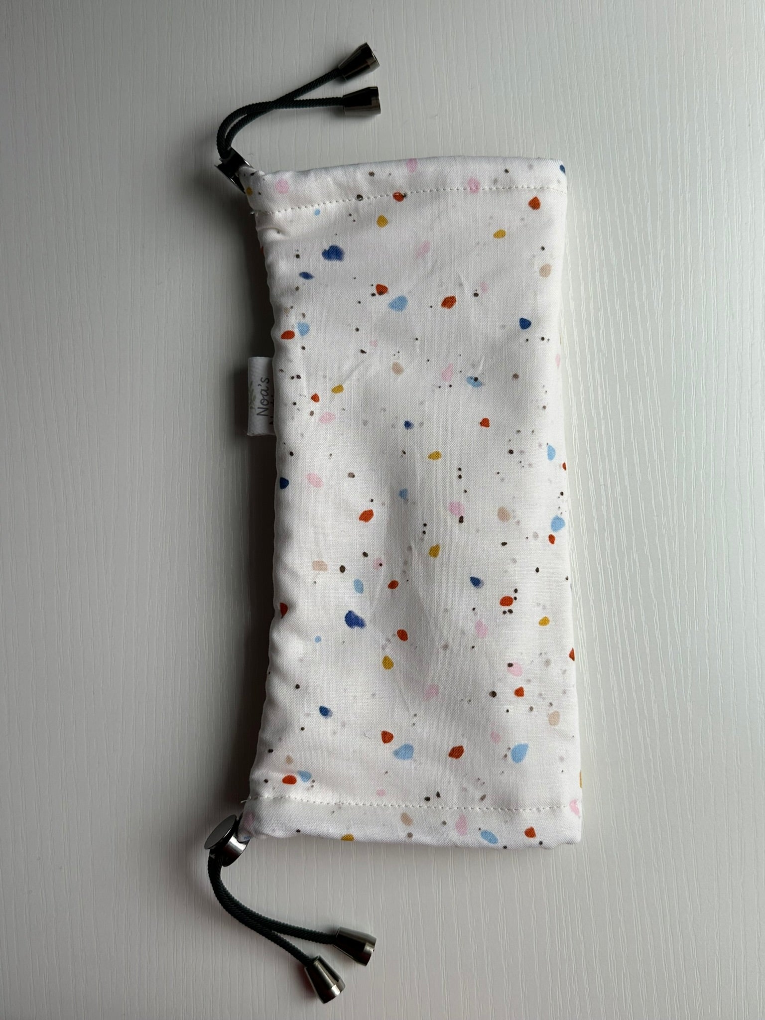 Sling Safe drawstring washing cover for ring slings, shown in the pattern Freckle. Freckle is a terrazzo pattern.