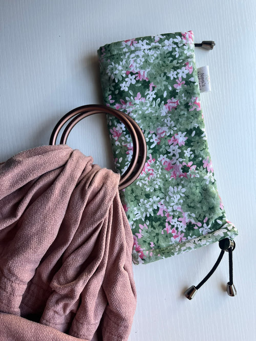 Floral drawstring bag with a pink ring sling on a light gray background
