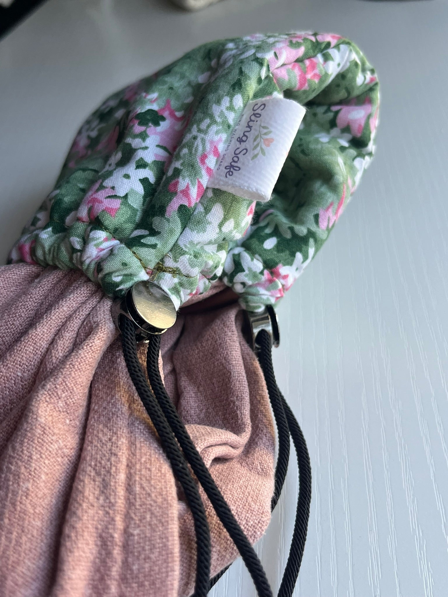 Floral drawstring bag with a visible brand label on a light background