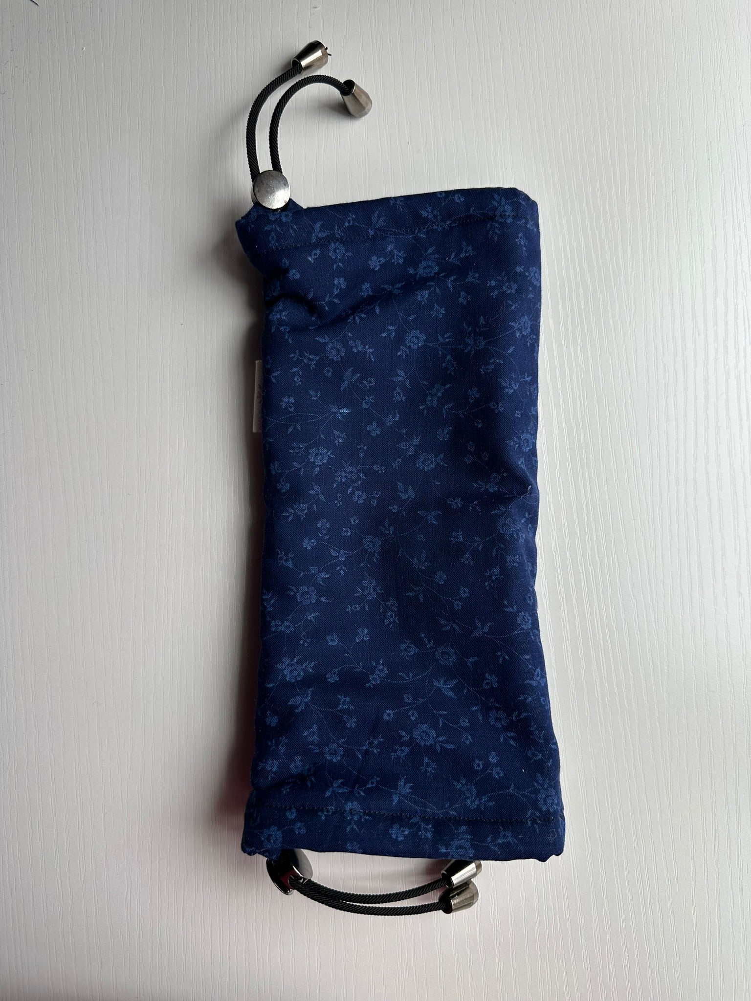 Sling Safe drawstring washing cover for ring slings, shown in the pattern Midnight Bloom. Midnight bloom is a navy on navy ditsy floral. 
